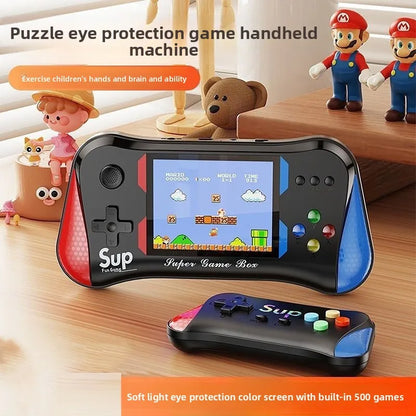 Handheld game console with colorful design on a wooden surface, surrounded by toys.
